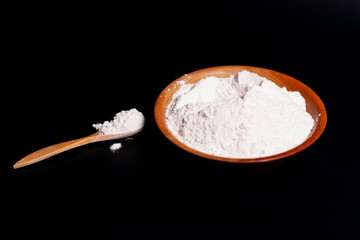 In the center of the screen is a brown Cup with a mound of flour. Wooden spoon nearby.