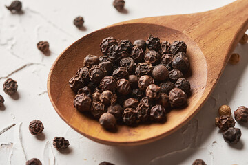 black pepper in spoon on white background