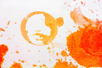 Fototapeta premium the round imprint of the glass of bright orange spots from spilled juice on a white background
