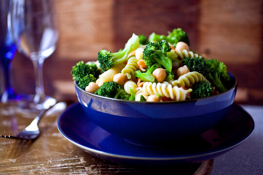 Pasta with broccoli and chickpeas in blue bowl