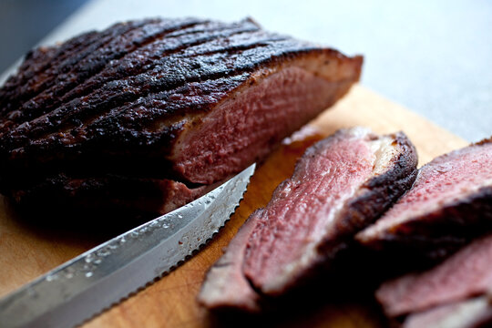 Close up of sliced grilled duck breast on cutting board