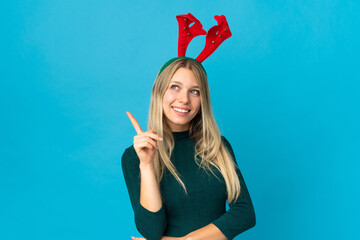 Woman with christmas hat isolated on blue background pointing up a great idea