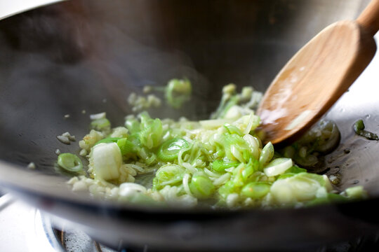 Close up of green onion on frying pan