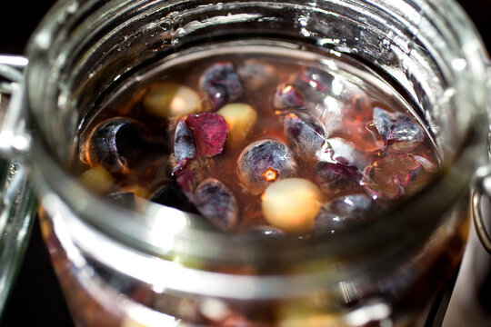 Close up of jar with boozy concord grapes