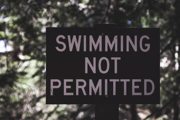 swimming not permitted sign at a lake in NY
concepts include warning, caution, direction
