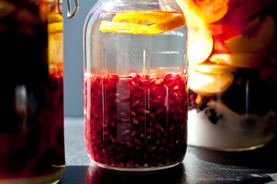 Close up of pomegranate in jar with gin