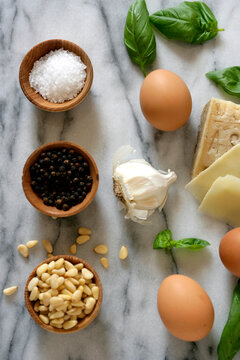 Close up of eggs, cheese, seeds, salt and black pepper on table