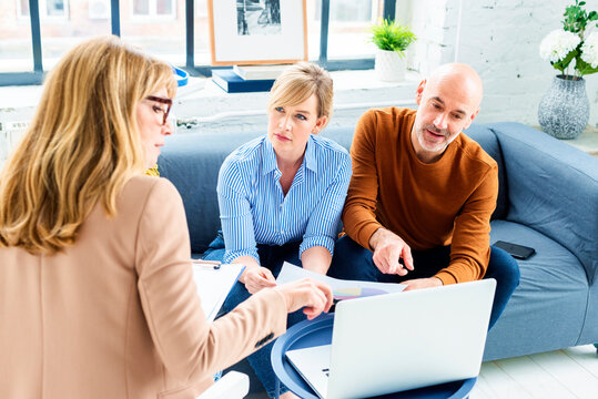 Couple Getting Advice From Businesswoman While Sitting At Home