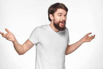 Bearded man in white t-shirt gesture with hands emotions light background