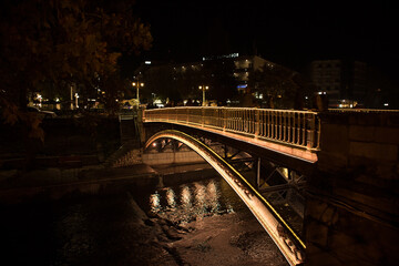 Fototapeta na wymiar A pedestrian bridge at a river, full of decorative christmas lights, during the christmas period.