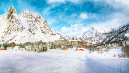 Gorgeous winter scenery with traditional Norwegian wooden houses and pine trees near Valberg village at Lofotens.
