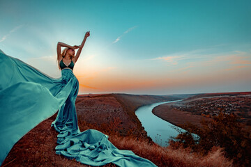 Beautiful female with long dress in sunset with the river