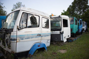 Abandoned parts from trucks, with faded color. Awaiting dismantling or recycling.