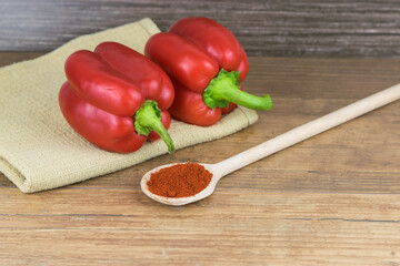 Natural, organic red pepper on wooden background with 
spice on a spoon