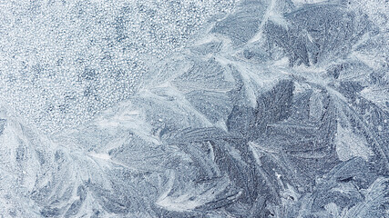 Frost patterns on the glass. Frozen surface. Cold weather. Background. Frosty drawing. The texture...
