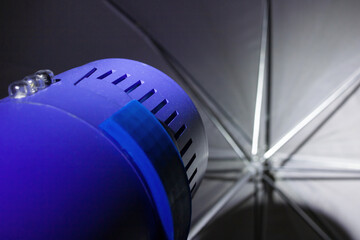 Flash and umbrella in the dark closeup