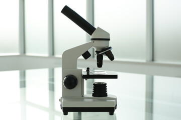 Microscope on a glass table in a bright room