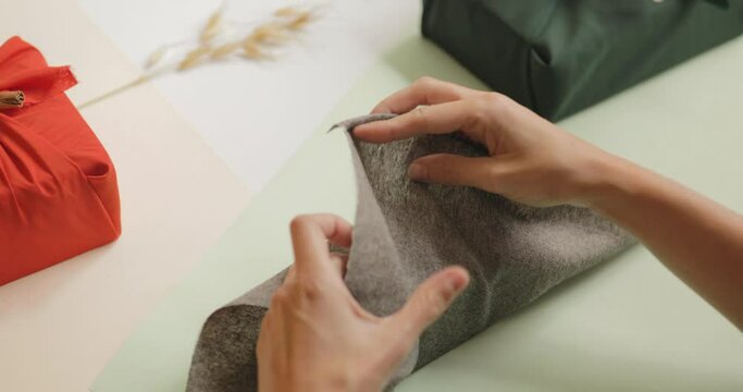 Woman hands preparing present, packing in wooden gift box in a gray cloth. Christmas and New year concept, 4k