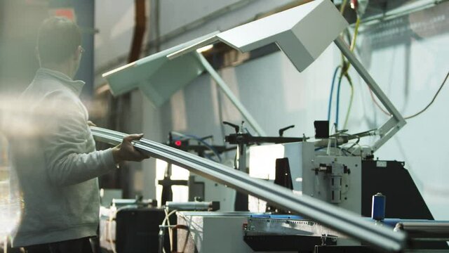 Person preparing metal profile for buzzsaw in big warehouse/workshop 4k PRORES Footage