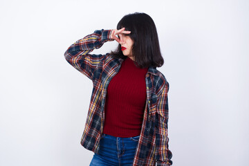 Displeased Beautiful young Caucasian woman standing against white background plugs nose as smells...