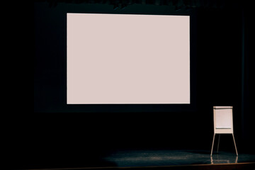 podium with white screen and flipchart in the hall of the business center