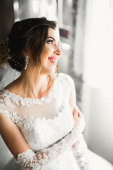 Luxury bride in white dress posing while preparing for the wedding ceremony