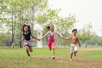 Group of kids running in the spring field at public park. Movement and blurry too soft. people children plying funny outdoors concept.