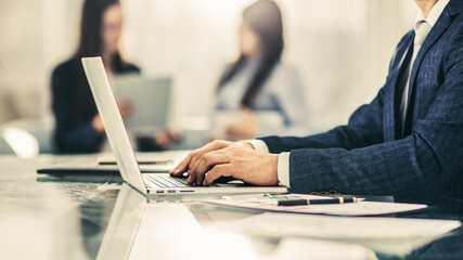 successful businessman working on laptop with financial data at the workplace in a modern office.