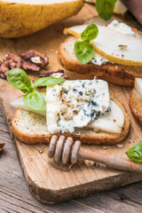 Toast or canape  with goat cheese, basil, honey, nuts.  Delicious appetizer, ideal as an aperitif.