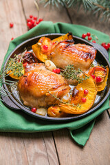 Roasted Christmas Chicken  thighs with pumpkin   for Christmas Dinner. Festive decorated wooden table