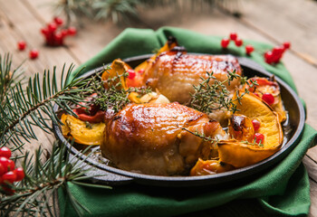 Roasted Christmas Chicken  thighs with pumpkin   for Christmas Dinner. Festive decorated wooden table