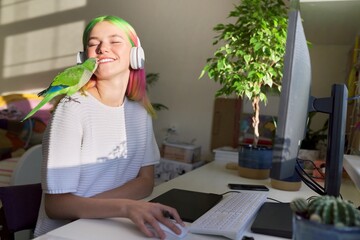 Student girl in headphones studying on computer with graphic tablet, with parrot © Valerii Honcharuk