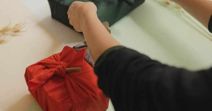 Young woman arranging wrapped gifts on a table, Christmas and New year minimalist concept. 4k