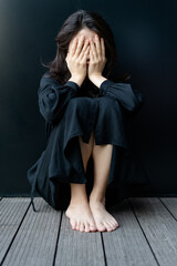 Depressed woman sitting on floor