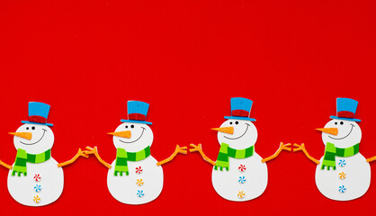 Christmas snowman made of paper, handmade, on a red background, garland. The view from the top. The concept of new year's Christmas.