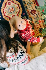 Christmas. Family. Fun. A mother plays with her young son on the floor near the Christmas tree at home. home comfort. christmas concept