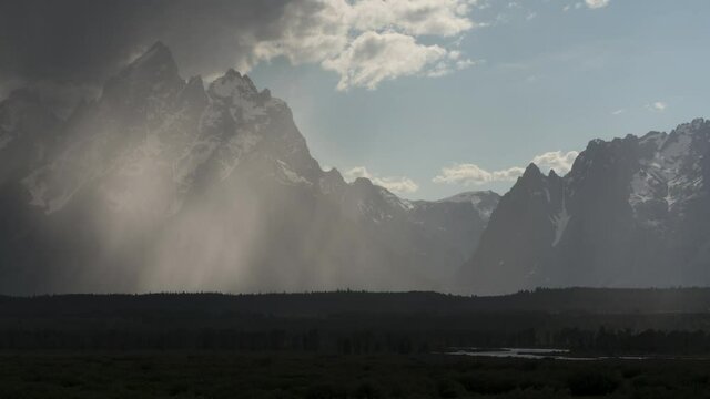 Timelapes from of cloudy and snowy Grand Tetons in Grand Teton National Park with storm clearing and reflection in clouds, Wyoming  