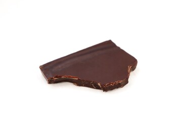 Bitten piece of chocolate on a white isolated background. Piece of milk chocolate on a white isolated background.