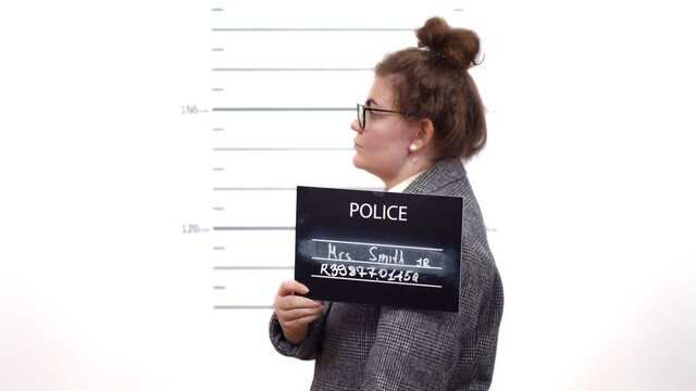 Arrested businesswoman posing for mugshot holding a signboard