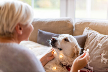 Woman and her dog enjoying Christmas together at home 
