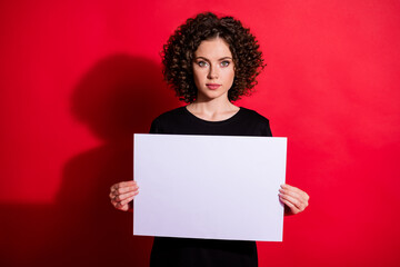 Photo of young person arms fingers holding white paper seriously looking isolated on bright red color background
