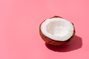 Fresh natural organic ripe half coconut fruit on a light pink background, copy space. Vegetarian...