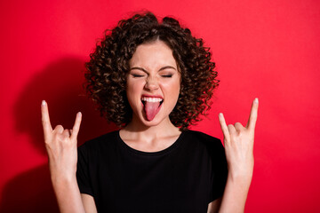 Portrait of attractive person stick tongue arms heavy metal sign wear black t-shirt isolated on red color background