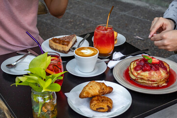 people having a brunch with pancakes, coffee and iced tea