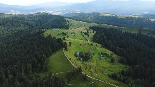 Fly over the small village in the Carpathian mountains. Aerial footage of a sunny summer evening in the contryside