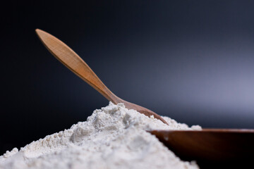 At the bottom of the screen is a Cup, a wooden spoon, and a pile of white flour. Side view.