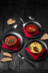 Laid table for a company with an assortment of soups: red borscht or kharcho, seafood cream soup or tom yam, tomato soup with beef or gazpacho. Festive table with delicious food.
