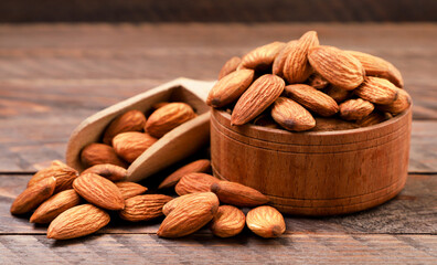 Almond nuts in a plate on a wooden background