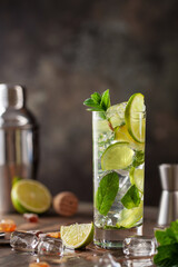 Mojito cocktail with lime and mint in glass on a grey background
