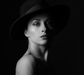 Beautiful makeup woman with elegant healthy neck, nude back and shoulder on black background in fashion hat with empty copy space. Closeup front view portrait.